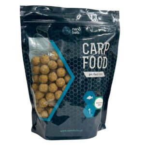 Obrazek przedstawia kulki zanętowe w torbie z okienkiem o wadze 1kg. Kulki są o smaku kukurydzy.