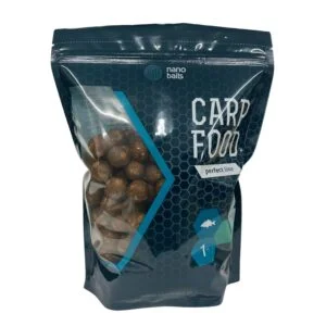 Obrazek przedstawia kulki zanętowe w torbie z okienkiem o wadze 1kg. Smak kulek to squid i mają kolor brązowy